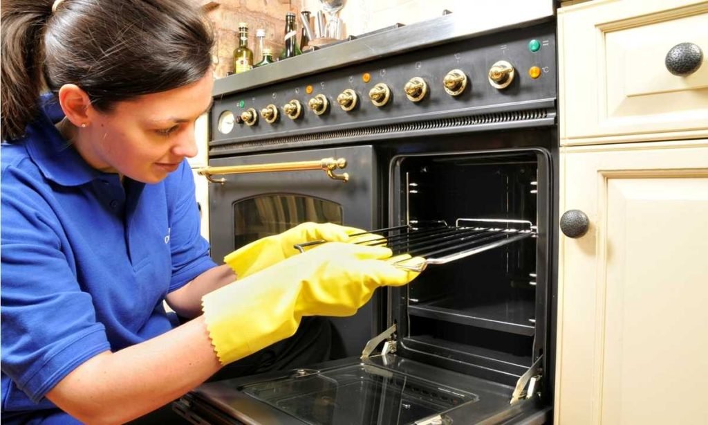 person cleaning oven